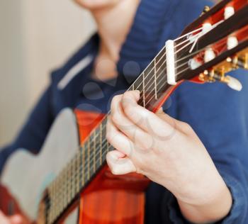 woman plays on modern acoustic guitar close up