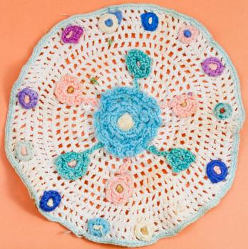 vintage knitting craftsmanship - flower ornament on placemat by crochet needlework