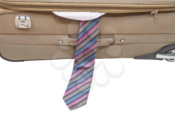 male tie from ajar suitcase isolated on white background