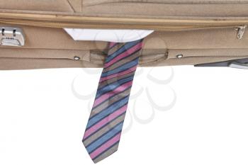 tie fell out of the half-open suitcase isolated on white background