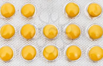 several yellow tablets in blister pack close up