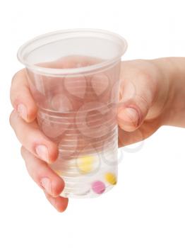 plastic cup with portion of tablets in hand isolated on white background
