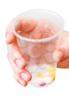 plastic cup with dose of tablets in hand isolated on white background