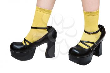 little girl in yellow socks trying on black platform shoes her mother
