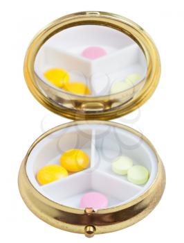 compact pill box with mirror and few tablets isolated on white background