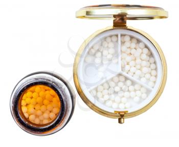 compact pill box and homeopathy sugar balls in glass brown jar isolated on white background