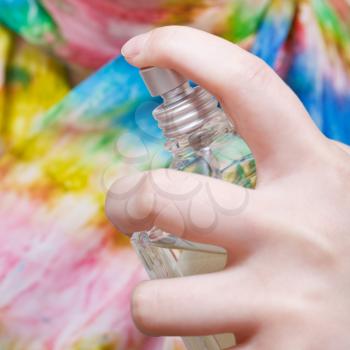 spraying of neckerchief from bottle of perfume close up