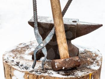 anvil with blacksmith hammer and tongs old country smithy in winter