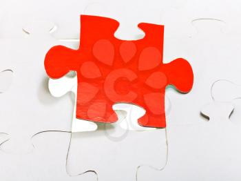 red puzzle piece attached in layer of assembled puzzles