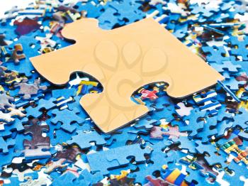 one big piece on pile of disassembled little blue jigsaw puzzles