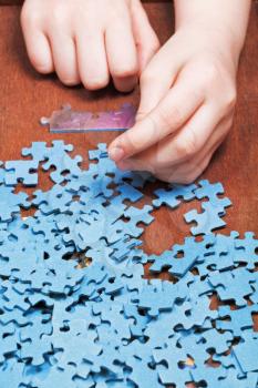 assembling of jigsaw puzzles on wooden table