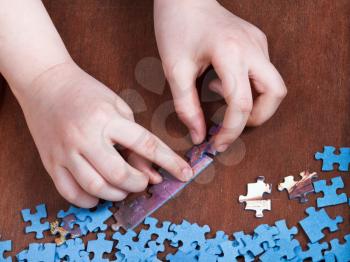 linking of jigsaw puzzles on wooden table