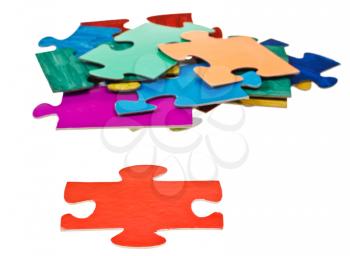 red puzzle piece in front of pile of jigsaw puzzles isolated on white background