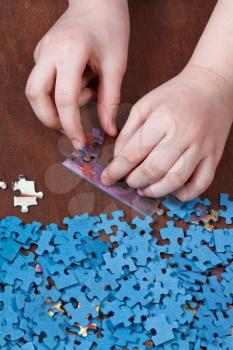 connecting of jigsaw puzzles on wooden table