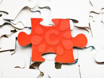 one red piece of puzzle on pile of white jigsaw puzzles