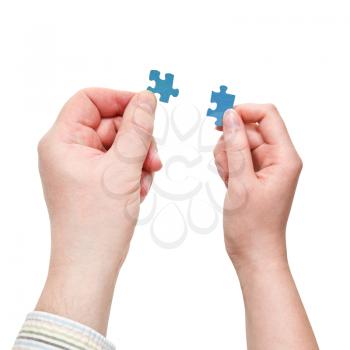 male and female two hands holding little puzzle pieces isolated on white background
