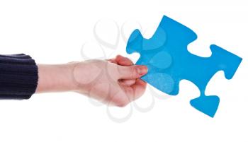 female hand holding big blue paper puzzle piece isolated on white background