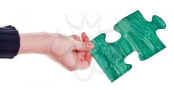 female hand with painted green puzzle piece isolated on white background