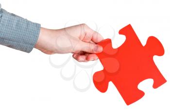 female hand holding big red paper puzzle piece isolated on white background