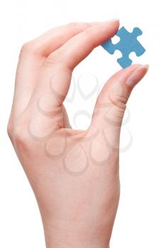 female arm holding blue puzzle piece isolated on white background