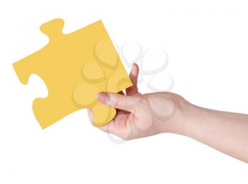 female hand with yellow puzzle piece isolated on white background