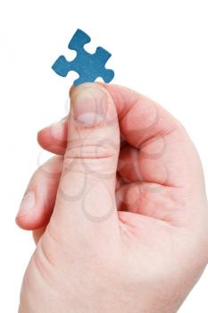 male fingers holding jigsaw puzzle piece isolated on white background