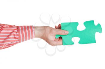 male hand holding big green paper puzzle piece isolated on white background