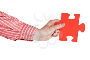 male hand holding big red paper puzzle piece isolated on white background