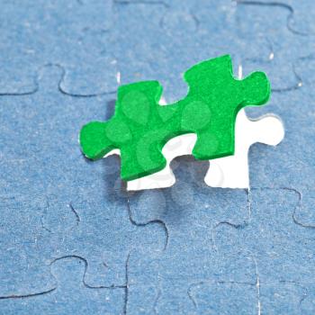 setting the last green piece of puzzle in free space in assembled jigsaw puzzles