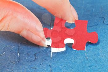 attaching the last red piece of puzzle in free space in assembled jigsaw puzzles