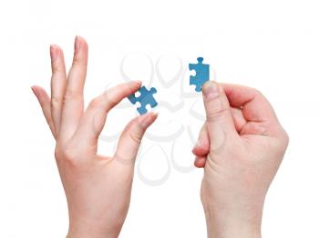 male and female hands connecting blue puzzle pieces isolated on white background