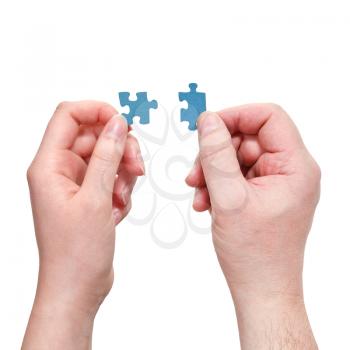 male and female hands connecting little puzzle pieces isolated on white background