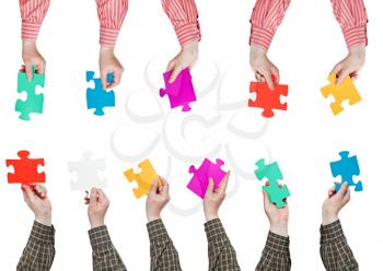 male hands in shirt sleeves with different puzzle pieces isolated on white background