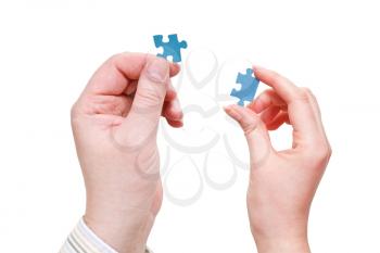 pair of male and female hands with blue puzzle pieces isolated on white background