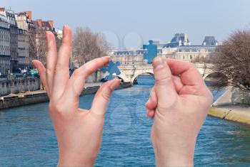 male and female hands with little puzzle pieces with Paris and Seine River background