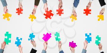set different puzzle pieces in people hands on grey background