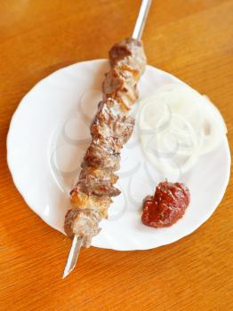 Crimean tatar cuisine - skewer of lamb shish kebab on white plate