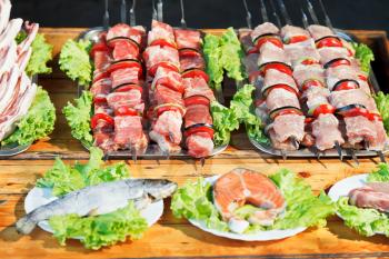 Crimean tatar cuisine - skewers of shishkebabs and raw fish for grill
