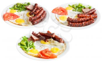 three plates with fried eggs, sausages, tomato, beans isolated on white background