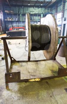 industrial wooden reel with steel wire rope in mechanical workshop