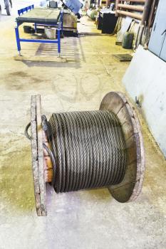 industrial wooden reel with steel rope in mechanical shop