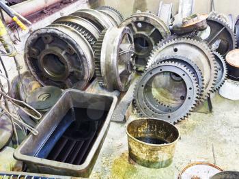 gears of disassembled engine on floor in mechanical workshop