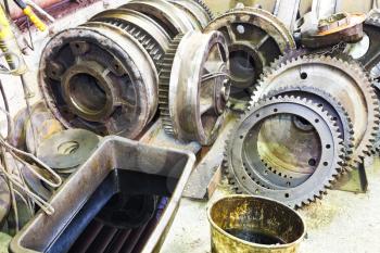 gears of disassembled motor on floor in mechanical turnery