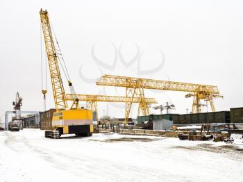 industrial landscape with different cranes in open storage area