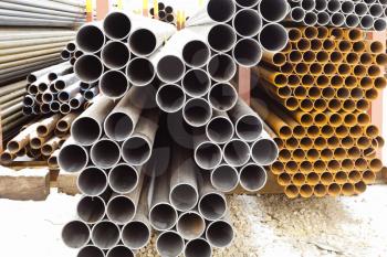 heap of metal pipes in outdoor warehouse in winter