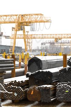storing of metal pipes in outdoor warehouse with gantry cranes