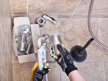plumber repairs sink chrome plated trap in bathroom