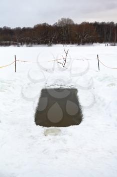 ice hole with frozen water in river in winter day