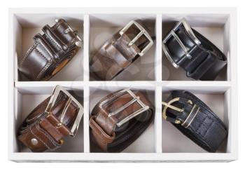top view of storage box with leather belts isolated on white background