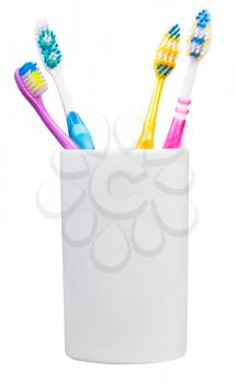 four tooth brushes in ceramic glass - family set of toothbrushes isolated on white background